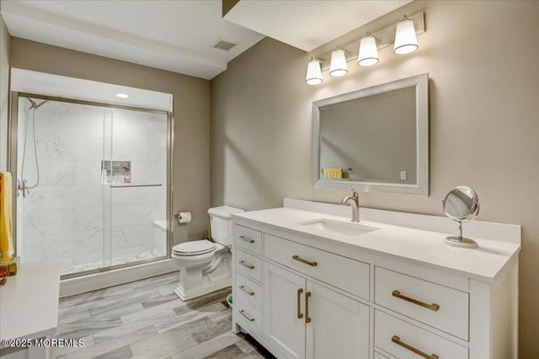 Bathroom, Dual Sink Vanities, Glass Shower, Interior, Marble Walls, Recessed Lighting, Wood Texture Flooring