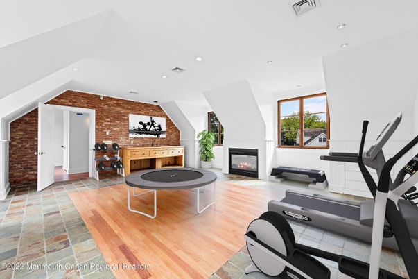 Fireplace, Fitness Equipment, Game Room, Interior, Recessed Lighting, Stone Walls, Wood Texture Flooring