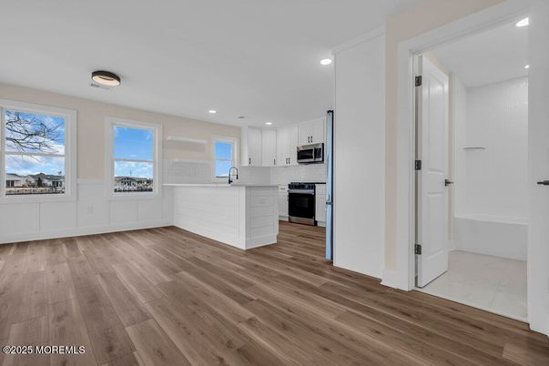 Empty room, Interior, Kitchen, Recessed Lighting, Stainless Steel Appliances, Wood Texture Flooring