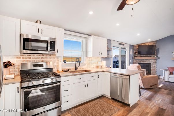 Fireplace, Interior, Kitchen, Recessed Lighting, Stainless Steel Appliances, Wood Texture Flooring