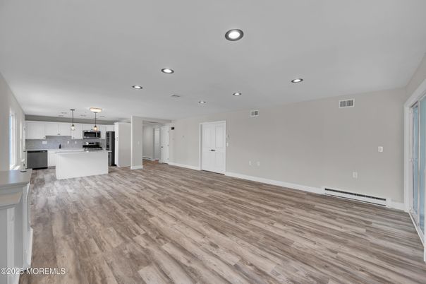 Empty room, Interior, Kitchen, Pendant Lights, Recessed Lighting, Stainless Steel Appliances, Wood Texture Flooring