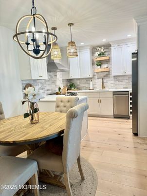 Chandelier, Dining room, Interior, Kitchen, Pendant Lights, Recessed Lighting, Stainless Steel Appliances, Stone Walls, Wood Texture Flooring