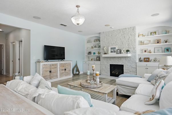 Chandelier, Fireplace, Interior, Living room, Recessed Lighting, Stone Walls, Wood Texture Flooring