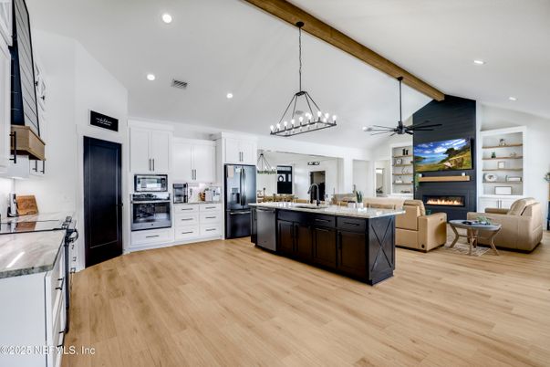 Chandelier, Fireplace, Interior, Kitchen, Living room, Pendant Lights, Recessed Lighting, Stainless Steel Appliances, Wooden Beams, Wood Texture Flooring