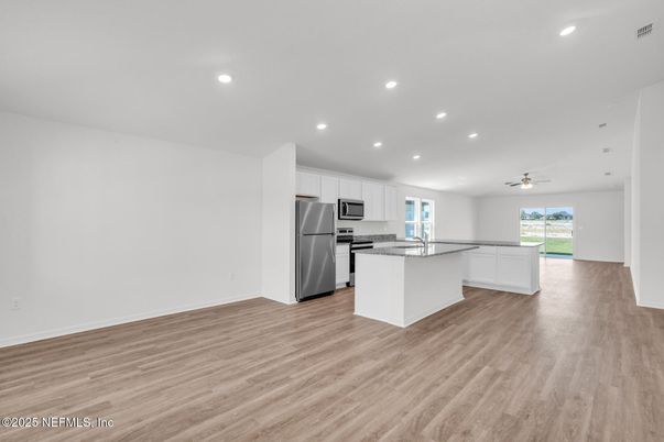 Empty room, Interior, Kitchen, Recessed Lighting, Stainless Steel Appliances, Wood Texture Flooring