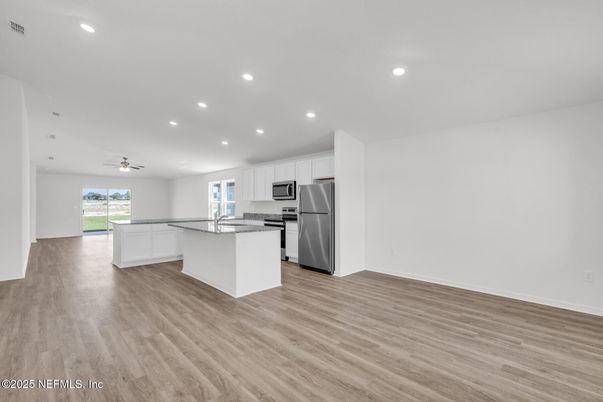 Empty room, Interior, Kitchen, Recessed Lighting, Stainless Steel Appliances, Wood Texture Flooring