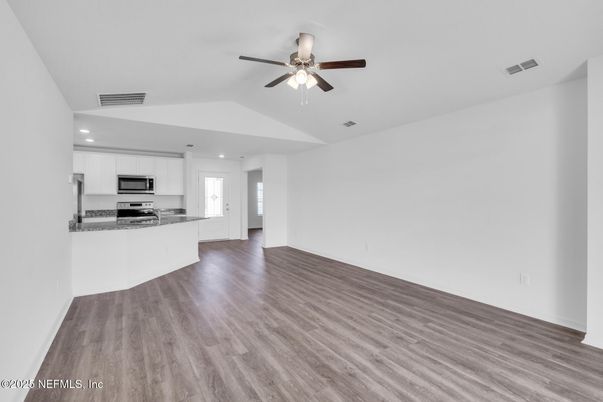 Empty room, Interior, Kitchen, Recessed Lighting, Stainless Steel Appliances, Wood Texture Flooring