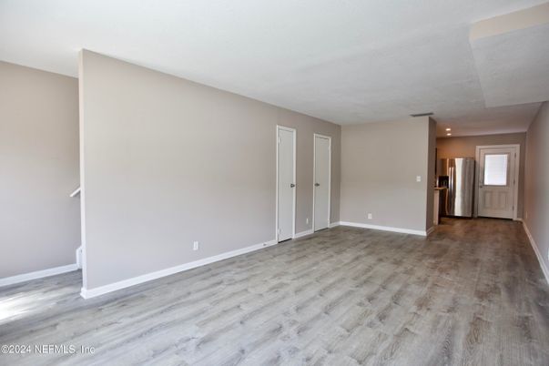 Empty room, Interior, Kitchen, Recessed Lighting, Stainless Steel Appliances, Wood Texture Flooring