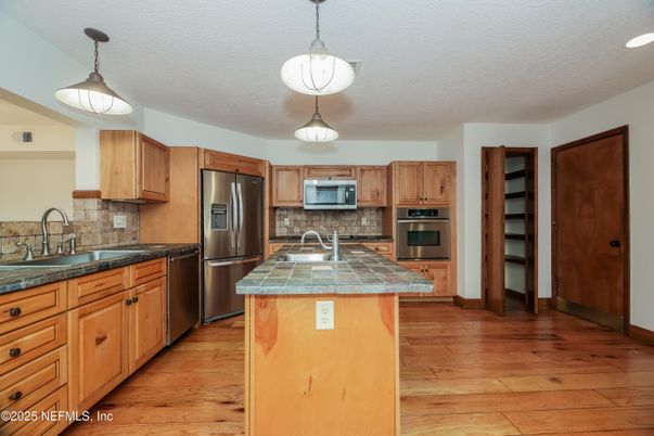 Interior, Kitchen, Pendant Lights, Recessed Lighting, Stainless Steel Appliances, Tile Countertops, Wood Texture Flooring