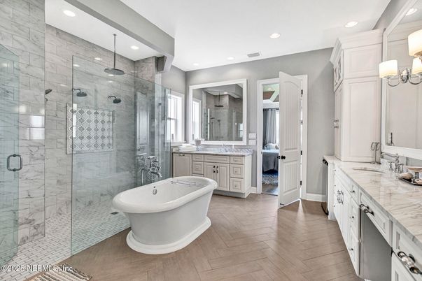 Bathroom, Dual Sink Vanities, Free Standing Baths, Glass Shower, Interior, Marble Walls, Recessed Lighting, Wood Texture Flooring