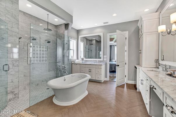 Bathroom, Dual Sink Vanities, Free Standing Baths, Glass Shower, Interior, Marble Walls, Recessed Lighting, Wood Texture Flooring