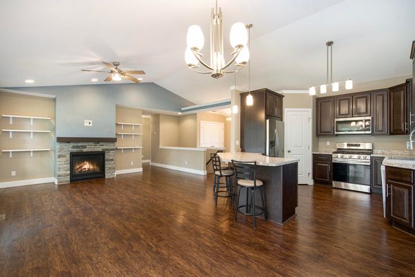 Chandelier, Empty room, Fireplace, Interior, Kitchen, Pendant Lights, Recessed Lighting, Stainless Steel Appliances, Wood Texture Flooring