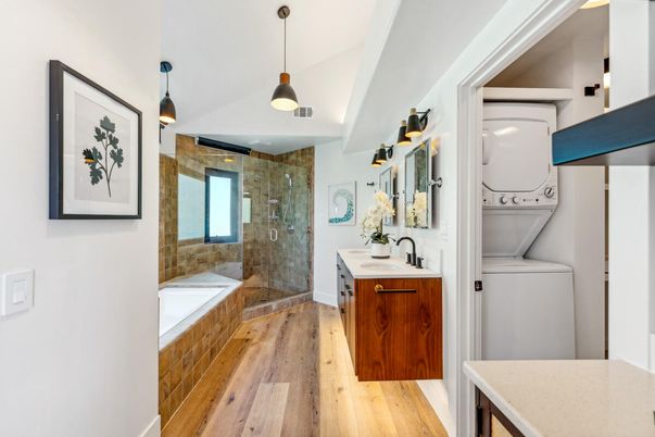 Bathroom, Dual Sink Vanities, Glass Shower, Interior, Pendant Lights, Stone Walls, Utility Closets, Washer, Wood Texture Flooring