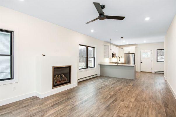 Empty room, Fireplace, Interior, Kitchen, Recessed Lighting, Stainless Steel Appliances, Wood Texture Flooring