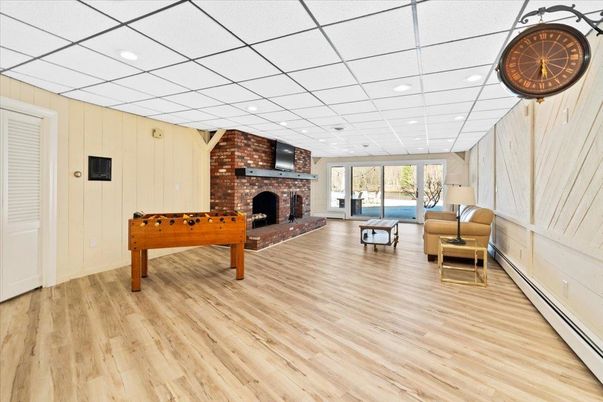 Fireplace, Game Room, Interior, Recessed Lighting, Stone Walls, Wood Texture Flooring