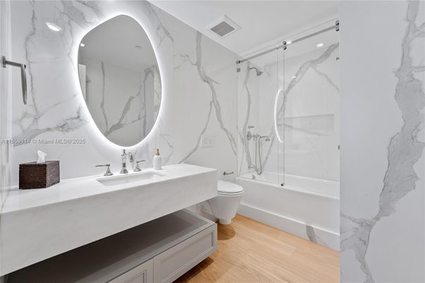 Bathroom, Dual Sink Vanities, Glass Shower, Interior, Marble Walls, Recessed Lighting, Wood Texture Flooring