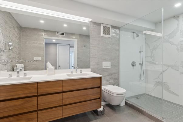 Bathroom, Dual Sink Vanities, Glass Shower, Interior, Marble Walls, Recessed Lighting, Wood Texture Flooring
