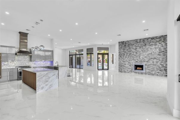 Fireplace, Interior, Kitchen, Marble, Pendant Lights, Recessed Lighting, Stainless Steel Appliances, Stone Walls