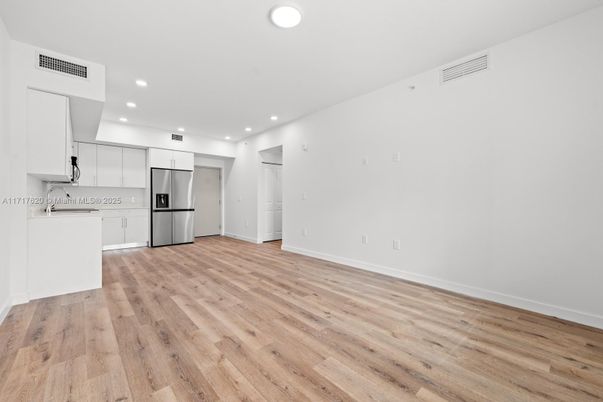Empty room, Interior, Kitchen, Recessed Lighting, Stainless Steel Appliances, Wood Texture Flooring