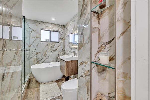 Bathroom, Free Standing Baths, Glass Shower, Interior, Marble Walls, Recessed Lighting, Wood Texture Flooring