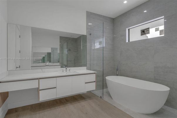 Bathroom, Dual Sink Vanities, Free Standing Baths, Glass Shower, Interior, Marble Walls, Recessed Lighting, Wood Texture Flooring