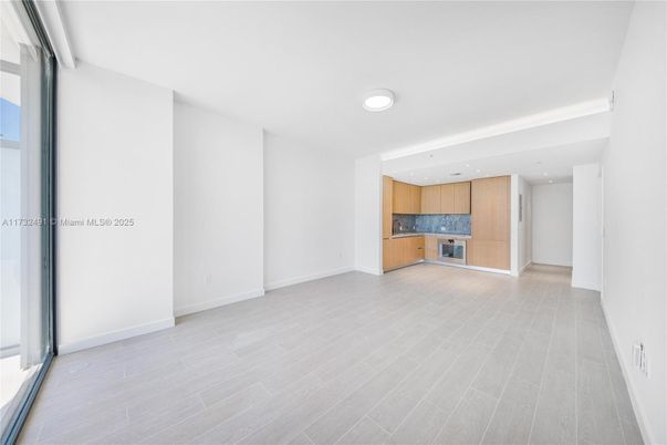 Empty room, Interior, Kitchen, Recessed Lighting, Stainless Steel Appliances, Wood Texture Flooring