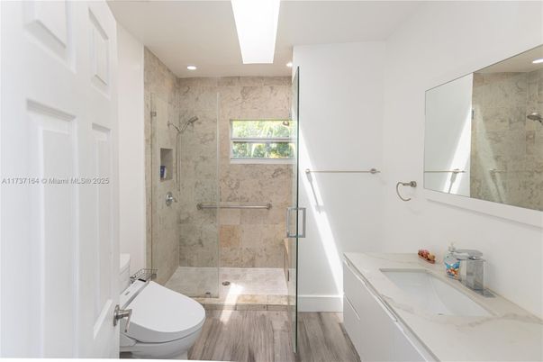 Bathroom, Dual Sink Vanities, Glass Shower, Interior, Marble Walls, Recessed Lighting, Wood Texture Flooring