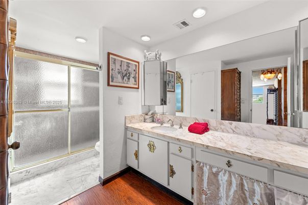 Bathroom, Dual Sink Vanities, Glass Shower, Interior, Marble, Recessed Lighting, Wood Texture Flooring