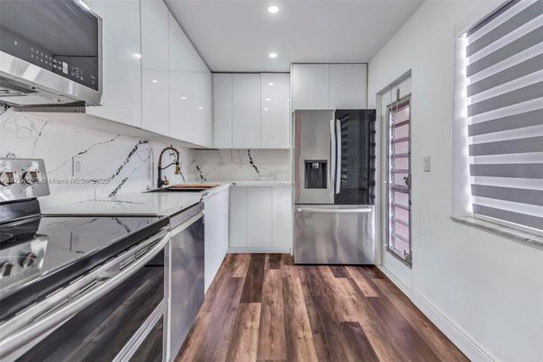 Interior, Kitchen, Marble Walls, Recessed Lighting, Stainless Steel Appliances, Wood Texture Flooring