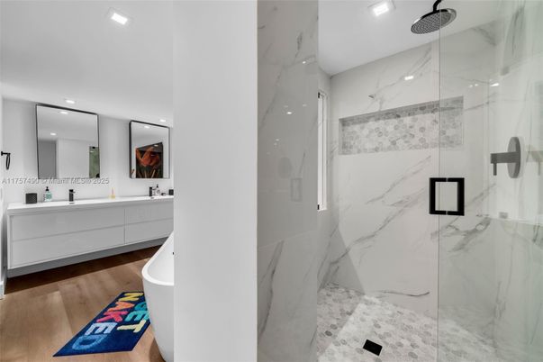 Bathroom, Dual Sink Vanities, Free Standing Baths, Glass Shower, Interior, Marble Walls, Recessed Lighting, Wood Texture Flooring