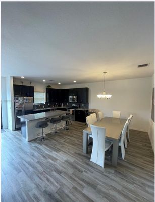 Chandelier, Dining room, Interior, Kitchen, Pendant Lights, Recessed Lighting, Stainless Steel Appliances, Wood Texture Flooring