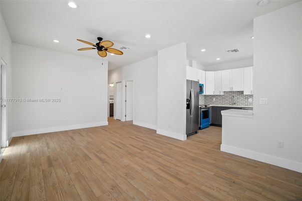 Empty room, Interior, Kitchen, Recessed Lighting, Stainless Steel Appliances, Wood Texture Flooring