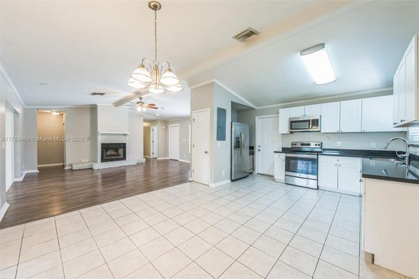 Chandelier, Fireplace, Interior, Kitchen, Pendant Lights, Stainless Steel Appliances, Wood Texture Flooring