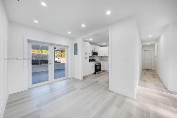 Empty room, Interior, Kitchen, Recessed Lighting, Stainless Steel Appliances, Wood Texture Flooring
