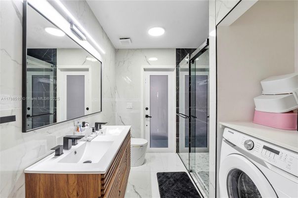 Bathroom, Dual Sink Vanities, Glass Shower, Interior, Marble, Marble Walls, Recessed Lighting, Washer