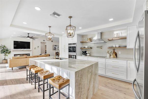 Chandelier, Fireplace, Interior, Kitchen, Living room, Pendant Lights, Recessed Lighting, Stainless Steel Appliances, Wood Texture Flooring