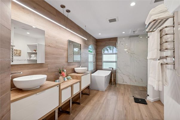 Bathroom, Dual Sink Vanities, Free Standing Baths, Glass Shower, Interior, Marble Walls, Recessed Lighting, Wood Texture Flooring