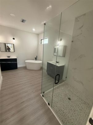 Bathroom, Free Standing Baths, Glass Shower, Interior, Marble Walls, Recessed Lighting, Wood Texture Flooring