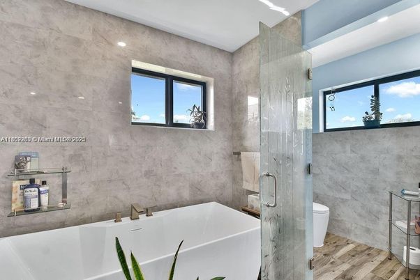 Bathroom, Free Standing Baths, Glass Shower, Interior, Marble Walls, Recessed Lighting, Wood Texture Flooring