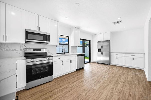 Interior, Kitchen, Marble Walls, Recessed Lighting, Stainless Steel Appliances, Wood Texture Flooring