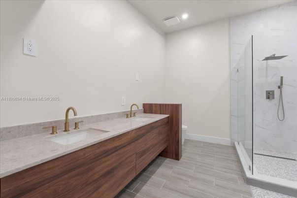 Bathroom, Dual Sink Vanities, Glass Shower, Interior, Marble Walls, Recessed Lighting, Wood Texture Flooring