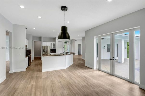 Empty room, Interior, Kitchen, Pendant Lights, Recessed Lighting, Stainless Steel Appliances, Wood Texture Flooring