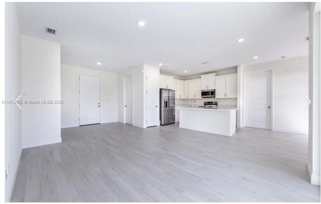 Empty room, Interior, Kitchen, Recessed Lighting, Stainless Steel Appliances, Wood Texture Flooring