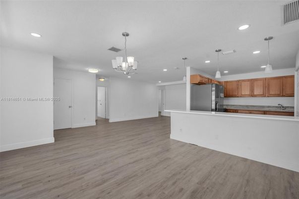 Chandelier, Empty room, Interior, Kitchen, Pendant Lights, Recessed Lighting, Stainless Steel Appliances, Wood Texture Flooring