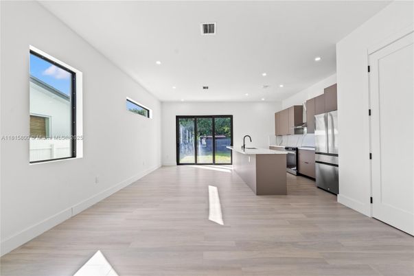 Empty room, Interior, Kitchen, Recessed Lighting, Stainless Steel Appliances, Wood Texture Flooring