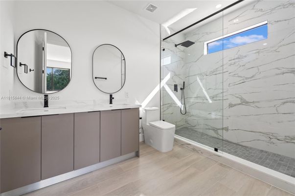 Bathroom, Dual Sink Vanities, Glass Shower, Interior, Marble Walls, Recessed Lighting, Wood Texture Flooring
