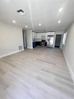 Empty room, Interior, Kitchen, Recessed Lighting, Stainless Steel Appliances, Wood Texture Flooring