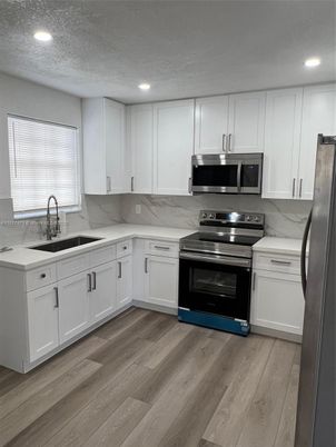 Interior, Kitchen, Marble Walls, Recessed Lighting, Stainless Steel Appliances, Wood Texture Flooring