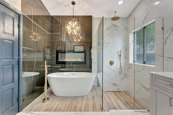 Bathroom, Fireplace, Free Standing Baths, Glass Shower, Interior, Marble Walls, Pendant Lights, Recessed Lighting, Wood Texture Flooring