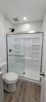 Bathroom, Glass Shower, Interior, Marble Walls, Recessed Lighting, Wood Texture Flooring